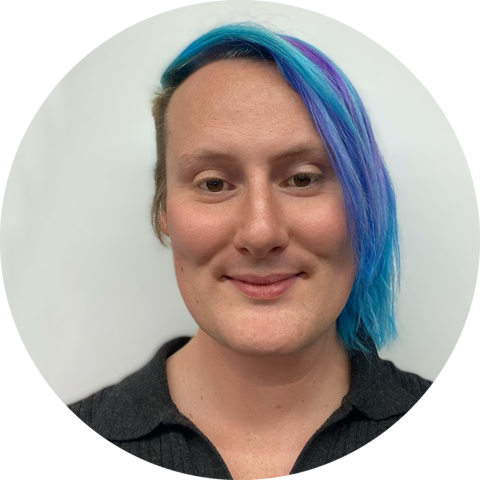 Charlotte Hadley, smiling, with blue and purple hair